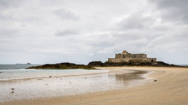 Plaj ve bulutlu bir günde yaz aylarında Saint Malo'da (Bretagne, Fransa) düşük gelgit sırasında Fort Ulusal