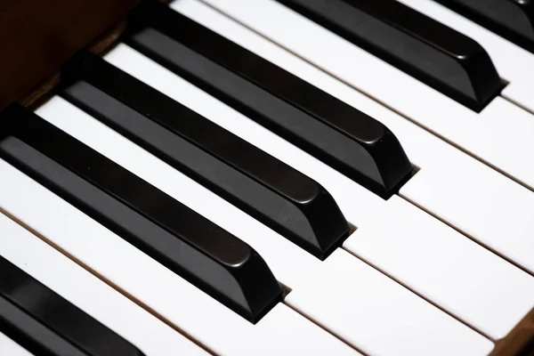 Closeup of piano keys of a light brown piano