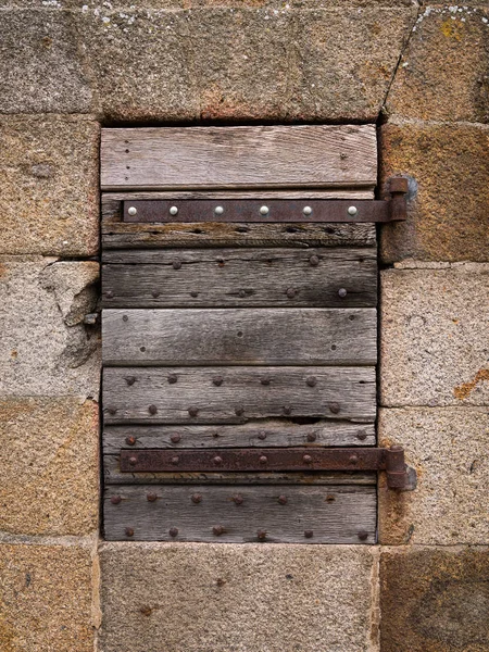 石の壁に古い閉じた木製ドアのクローズ アップ — ストック写真