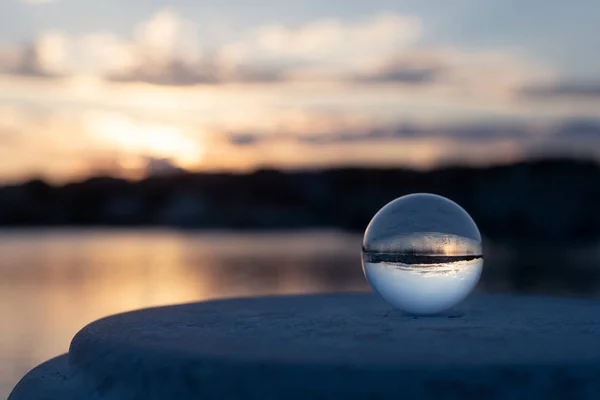 Sunset through glass ball in the harbor of Cres on a partly cloudy day in spring