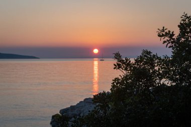 Hırvatistan'da deniz üzerinde gün batımı, mavi gökyüzü