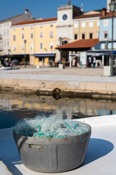 a bucket full of fishing nets standing in a port