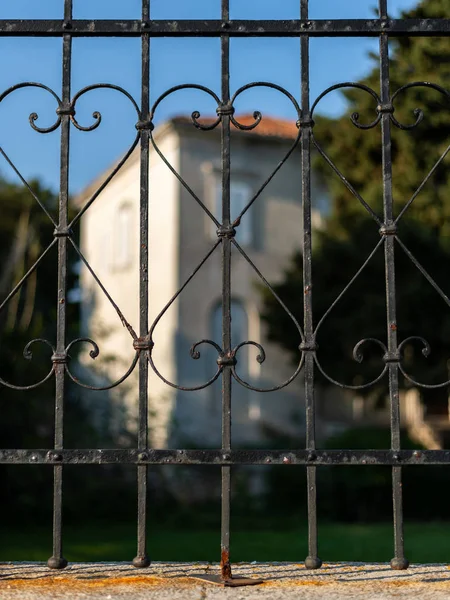 Puerta de metal oxidado y una gran casa en el sol de la noche —  Fotos de Stock