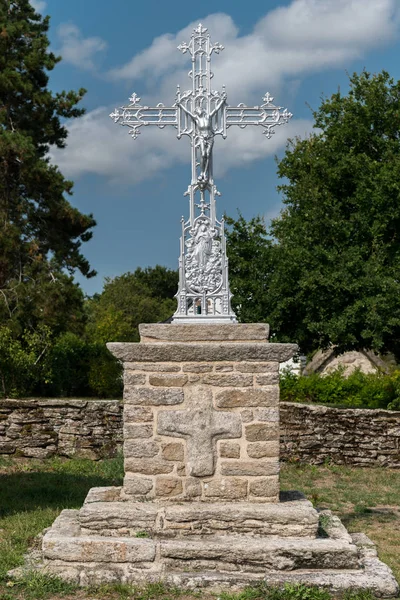 Moderne metalen Kruis staande op een stenen muur — Stockfoto
