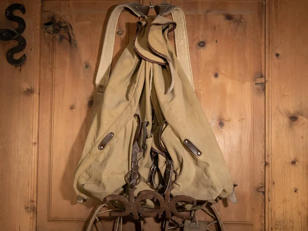 Ein sehr alter Rucksack hängt an einer Holzwand — Stockfoto