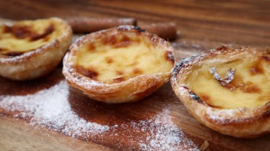 Pastel de nata Portekiz 'in ünlü tatlısıdır. Ahşap arka planda Pastel de Belem.