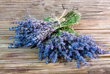 Lavanta lavanta ahşap arka plan üzerinde başka bir buket yatan bir kaba iple bağlı, bir buket bir fotoğraf