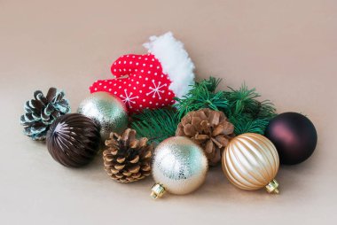 Noel Baba, dekoratif bir eldiven çevresinde resmi yalan Noel oyuncaklar, çam kozalakları ve köknar ağacı dalı bej renkli bir arka plan üzerinde