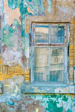 Eski bir pencere çerçevesinin eski harap duvar içinde cam ve metal çubuklarla renkli fotoğraf