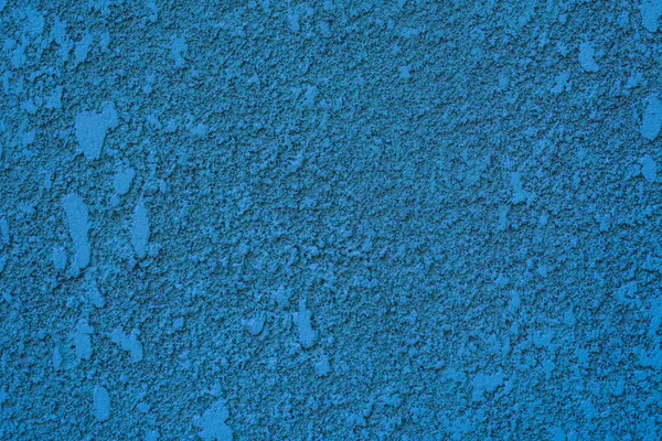 Photo of a wall with blue textured relief stucco close up