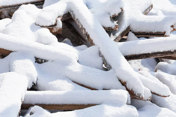 Foto Barras Tablones Madera Arrojados Caóticamente Una Pila Cubiertos Nieve —  Fotos de Stock