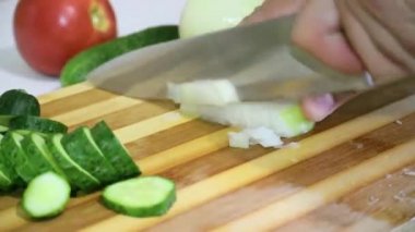 Taze soğan domates ve doğranmış salatalık closeup büyük bir bıçak ile kesme tahtası üzerinde Dilimleme