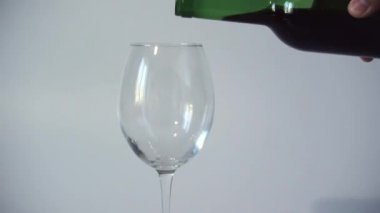 Şarap, bir şişeden şeffaf boş bir cama dökülür. Close