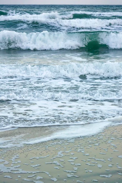 海浪特写与海泡在沿海风沙上的垂直照片 — 图库照片