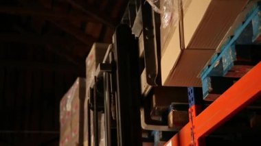 Çatal yükleyici bir raf kutuları kaldırır. Ambar.