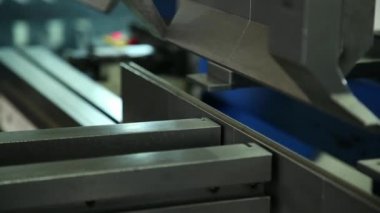 Kalıplama metal ayrıntılar makinesi üzerinde. İşçi çalışıyor. Metal levha bir detay oluşturur. Dükkanda iş.
