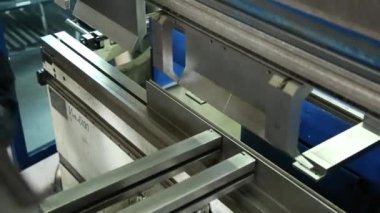 Kalıplama metal ayrıntılar makinesi üzerinde. İşçi çalışıyor. Metal levha bir detay oluşturur. Dükkanda iş.