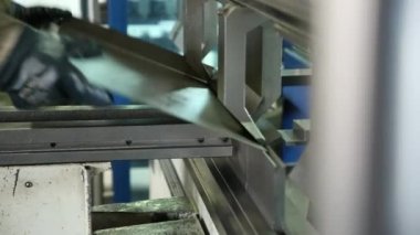 Kalıplama metal ayrıntılar makinesi üzerinde. İşçi çalışıyor. Metal levha bir detay oluşturur. Dükkanda iş.