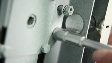 İşçi figürlü bir anahtar bir somun güvenli kilitleme mekanizması içinde katlanmış. Yakın çekim. Yalnızca çalışanın parmak görülebilir. Yakın çekim. •Tüm aksesuarlarý ve metal renk anahtar.