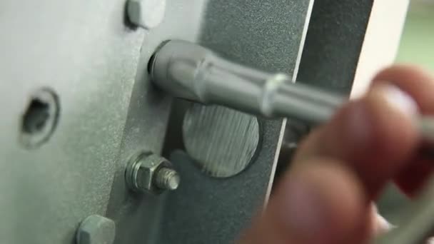 工人一把螺母拧在保险柜的锁紧机构中 关门了只有雇员的手指是可见的 关门了所有配件和金属颜色的关键 — 图库视频影像