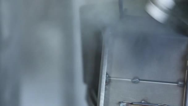 L'employé l'équipement spécial peint le coffre-fort. Le coffre-fort est suspendu au-dessus d'un plancher sur des crochets. Ferme là. Les mains de l'employé sont visibles. Il n'y a personne dans un coup. .