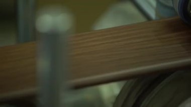 Bir Plinth üzerinde koruyucu bir film yapıştırma sürecinin çekim. Film yapıştırıldı. Bir Plinth yakın. Kaide silindirleri ile yapıştırma için ekipman geçer. Süpürgelik. Üretim. İnşaat kaplama.