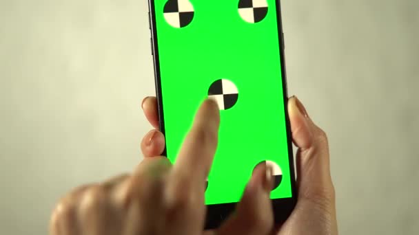 スマートフォンの緑色の画面が削除されます 女性の手は スマートフォンの緑色の画面上で操作を行います 手とスマートフォンをクローズアップします 最初は垂直で 次に水平方向にスマートフォン — ストック動画