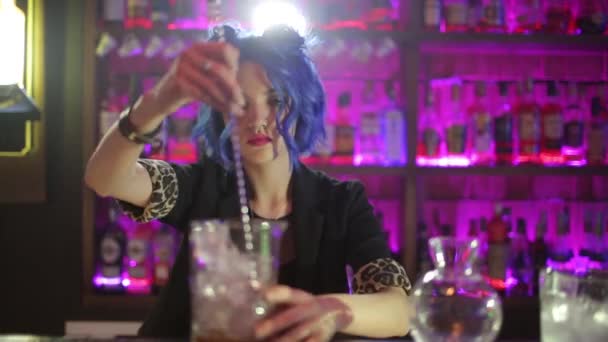 Барменша. девушка с голубыми волосами. приготовление коктейлей в ночном баре — стоковое видео