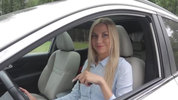 Negocio de automóviles, venta de coches, el consumismo y el concepto de la gente - mujer feliz tomando la llave del coche del distribuidor en el espectáculo o salón de automóviles . — Vídeo de stock