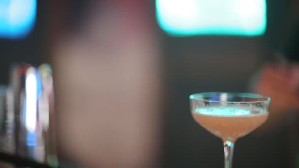 O barman especialista está a fazer cocktails no clube nocturno. Barman profissional no trabalho em bar derramando bebida doce em vidro na festa na boate. Barman está decorando coquetel . — Vídeo de Stock
