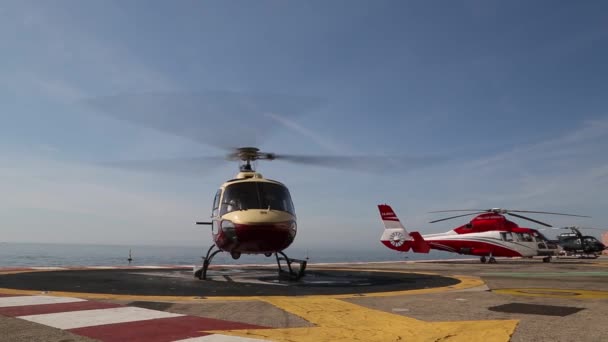 Monaco - februari 13, 2018: Een helikopter op het plat formulier boven de zee in de Monte Carlo International helihaven. Deze helihaven is de enige luchtvaart faciliteit in het Prinsdom. — Stockvideo