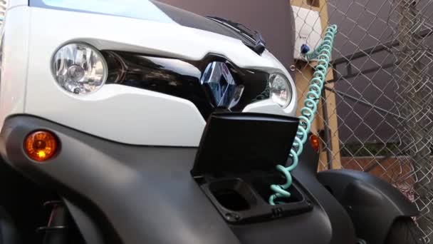 MONACO, MONAKO - 5 July, 2018: Black micro-car Renault model Twizy recharging on city street plugged in with extendable cable. — Stock Video