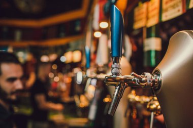 Barmen elleri bardağa bira dolduruyor..