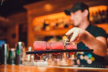 Barmen tekila çubuğunun arka planı cam içine yağıyor.
