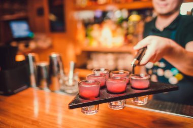 Barmen tekila çubuğunun arka planı cam içine yağıyor.