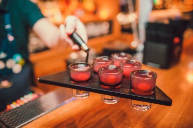Barmen tekila çubuğunun arka planı cam içine yağıyor.