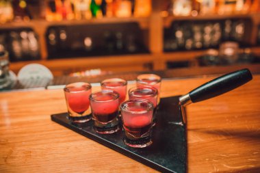 Barmen tekila çubuğunun arka planı cam içine yağıyor.