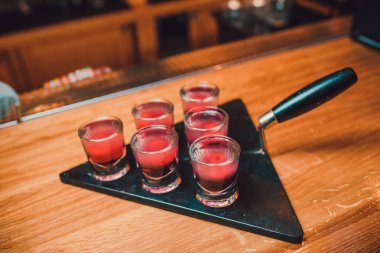 Barmen tekila çubuğunun arka planı cam içine yağıyor.