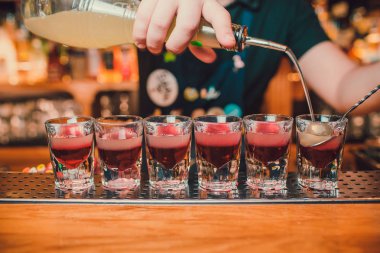 Barmen tekila çubuğunun arka planı cam içine yağıyor.