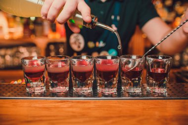 Barmen tekila çubuğunun arka planı cam içine yağıyor.