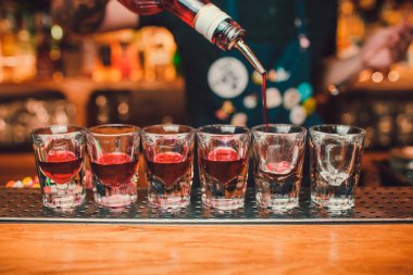 Barmen tekila çubuğunun arka planı cam içine yağıyor.