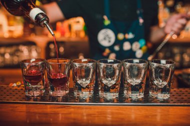 Barmen tekila çubuğunun arka planı cam içine yağıyor.