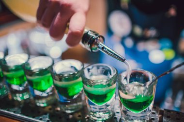 Fondip bardakları tezgahta duran yeşil sıvı. barmen görüntüleri hazırlama