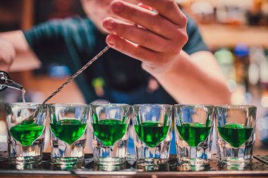 Fondip bardakları tezgahta duran yeşil sıvı. barmen görüntüleri hazırlama