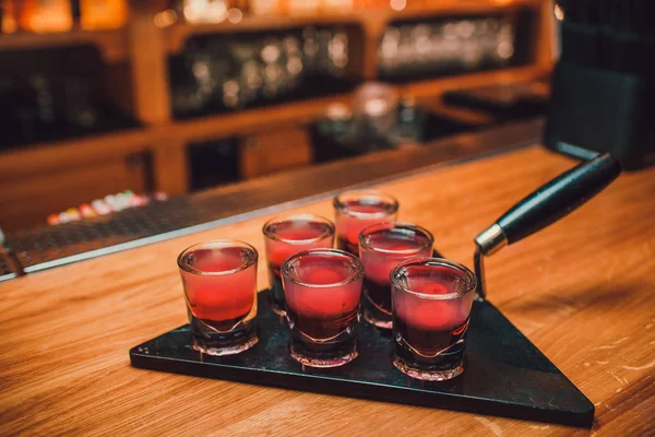 Barkeeper gießt Tequila ins Glas vor dem Hintergrund der Bar. — Stockfoto