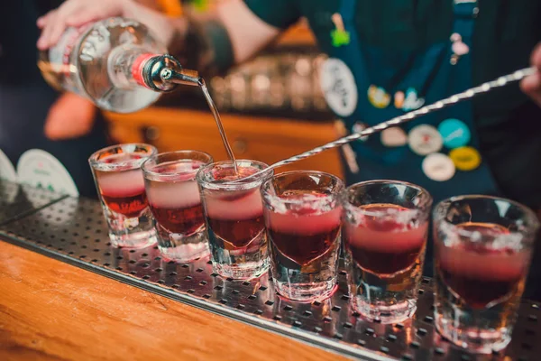 Barmen tekila çubuğunun arka planı cam içine yağıyor.