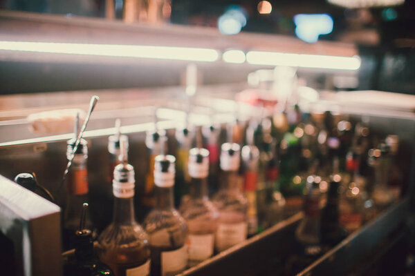 out of focus bar, shelf of alcoholic bottles.