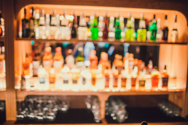 out of focus bar, shelf of alcoholic bottles.
