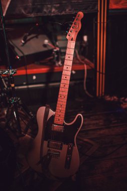 Kırmızı elektro gitar ve karanlık bir arka plan üzerinde klasik amplifikatör.