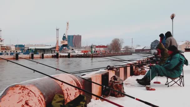 Ventspils, LATVIA. - 10 Dezembro 2017: Pessoas de pé em toupeira e olhando para o porto congelado — Vídeo de Stock